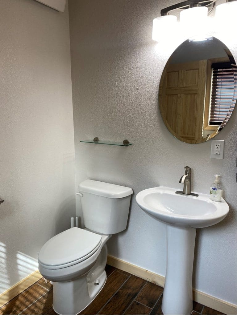 toilet and vanity with mirror in 400sq Ft deluxe cabins