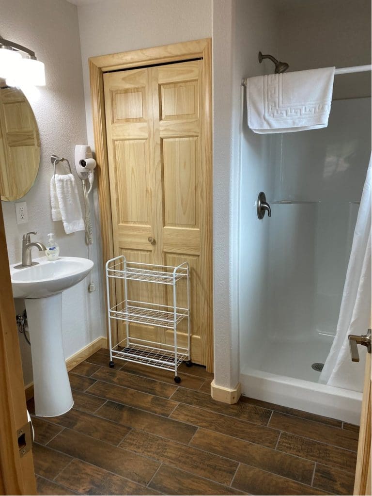 Bathroom view of 400 sq ft deluxe cabin with shower, mirror and sink.